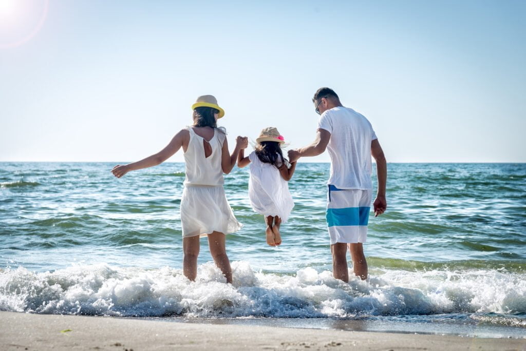 Expat Advisory_Family lifting daughter over the sea