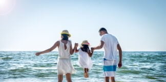 Expat Advisory_Family lifting daughter over the sea