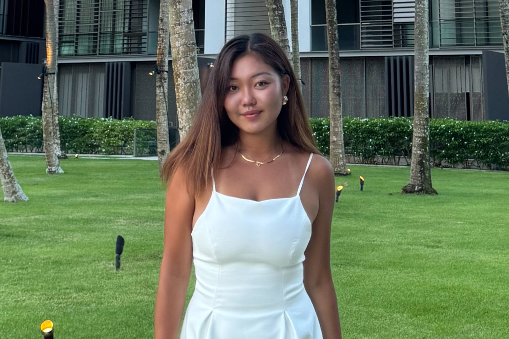 AIS Student standing in fron of school