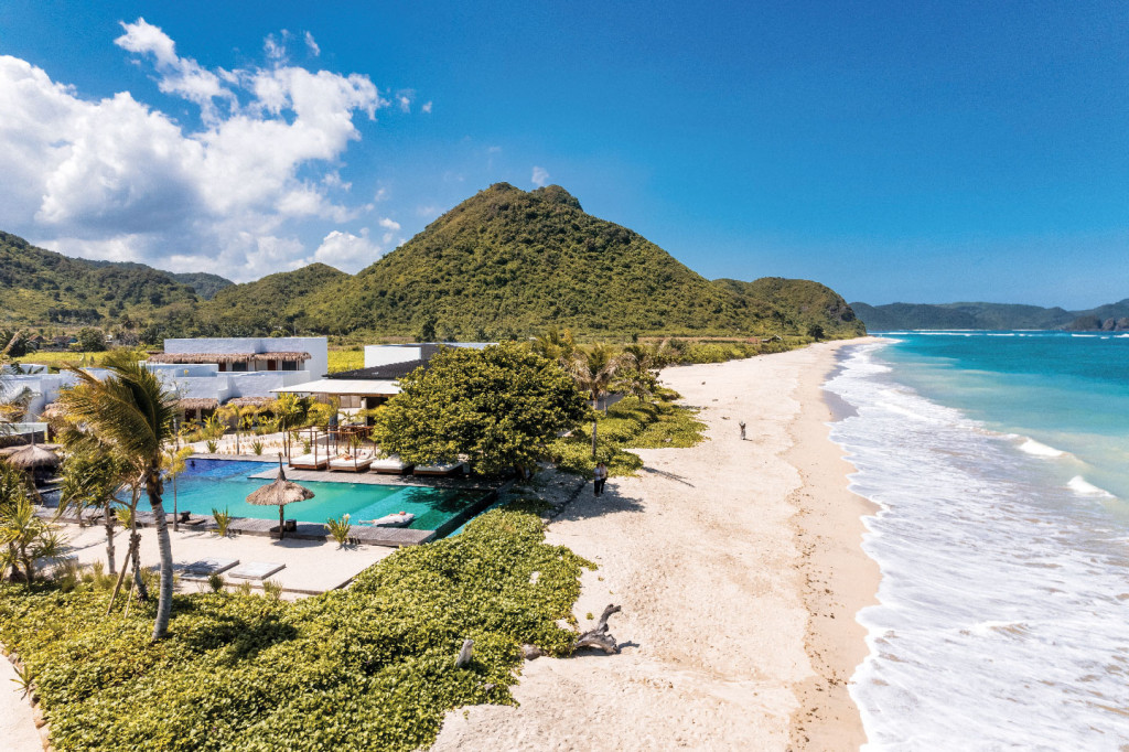 Amber Beachfront resort with mountain backdrop and turquoise sea.